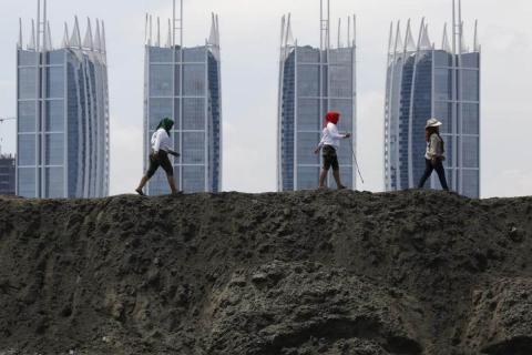 Women activists walk on top of reclaimed land during a protest against land reclamation in Jakarta Bay, Indonesia, in this April 17, 2016. REUTERS/Beawiharta/File